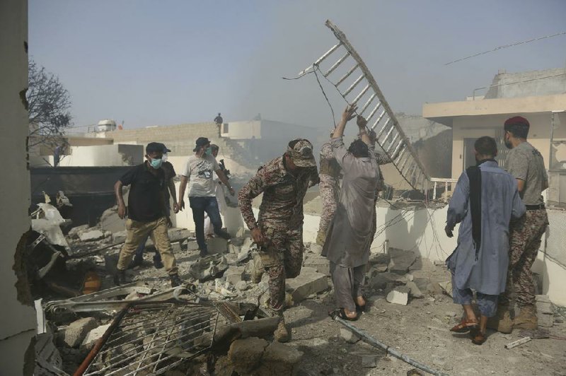 Rescue workers search the rubble Friday after a passenger jet crashed into a neighborhood in Karachi, Pakistan. More photos at arkansasonline.com/523pakistan/
(AP/Fareed Khan)