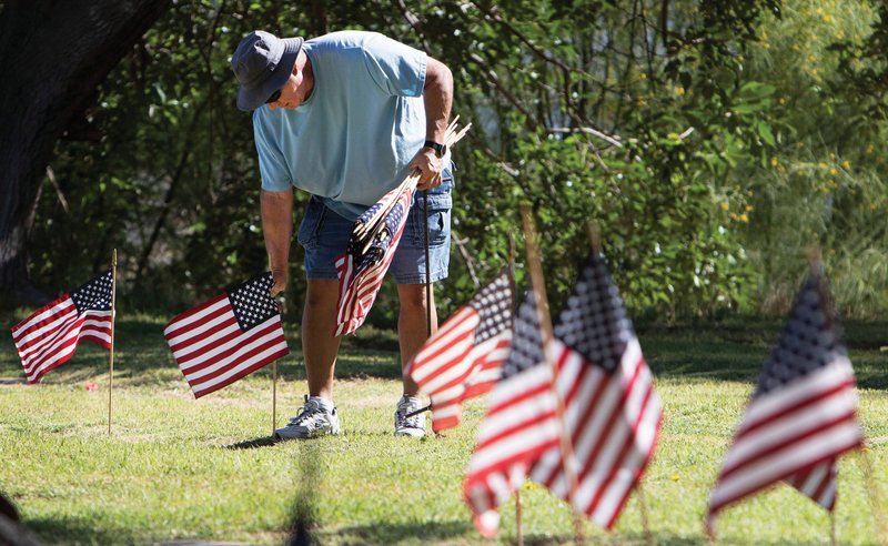 Jaime Aviles, who served in the U.S. Navy from 1974-79, places American flags at the graves of military veterans Saturday to prepare for Memorial Day at Evergreen Cemetery in Tucson, Ariz.
(AP/Arizona Daily Star/Rick Wiley)