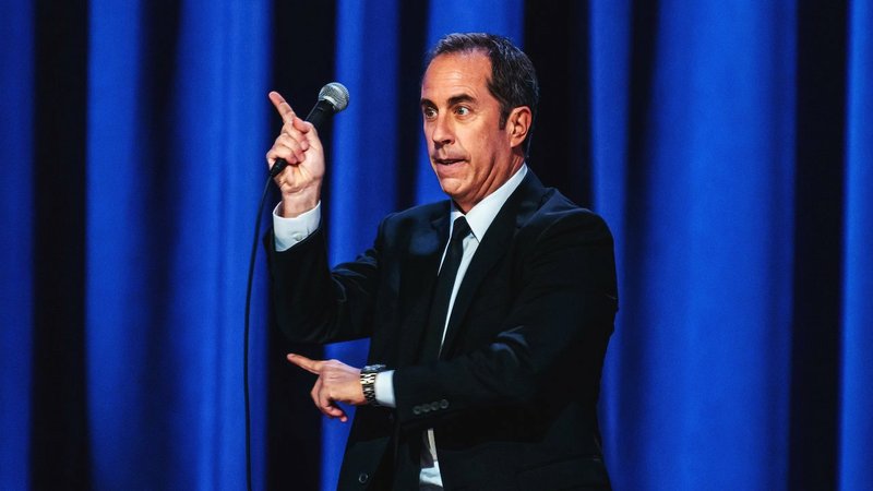 Jerry Seinfeld is wearing a Breitling Aerospace EVO Titanium 42mm watch with white dial in this shot from his Netflix Comedy Special 23 Hours to Kill.