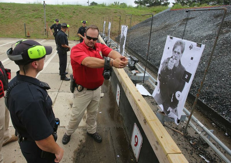 Firearms instructor Mitchel Jackson (center) talks with cadet Robert Scoggin during a training session Friday at the Little Rock police training academy. More photos at arkansasonline.com/525lrpd/. (Arkansas Democrat-Gazette/Thomas Metthe) 
