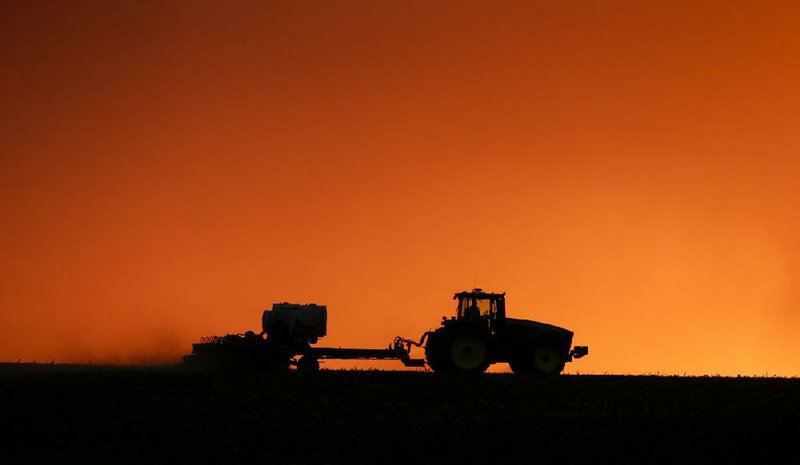 In this April photo, a farmer is silhouetted by the setting sun as a field is planted near Walford, Iowa.
(The Gazette -via AP/Joe Slosiarek)