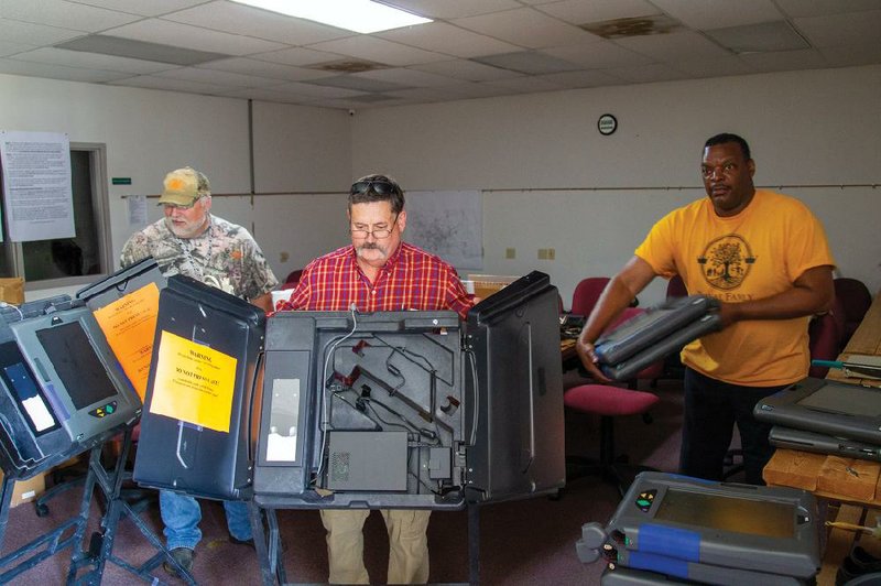 Jefferson County Employees, from left, Luke Eheman, Warner Worthan, and Anthony Royal salvage some electrical components from voting machines at the Jefferson County Election Commission office in preparation for discarding the machines. The iVotronics touch-screen machines that have been in use for elections since 2003 will soon be replaced by the newest generation of voting machines from Election Systems & Software, the Nebraska company that supplies most of the counties in Arkansas with voting systems. (Arkansas Democrat-Gazette/Dale Ellis)