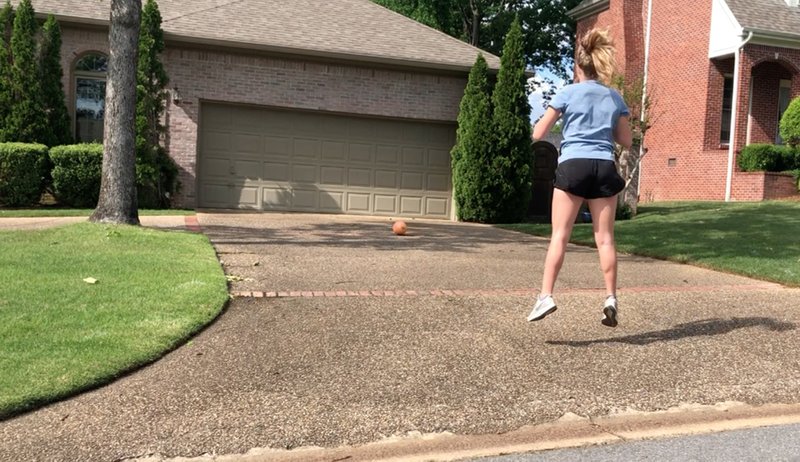 Meredith Pinkston does as many jump squats as she can while the ball rolls back toward her, the second leg of the Driveway Challenge for Matt Parrott's Master Class. (Arkansas Democrat-Gazette/Celia Storey)