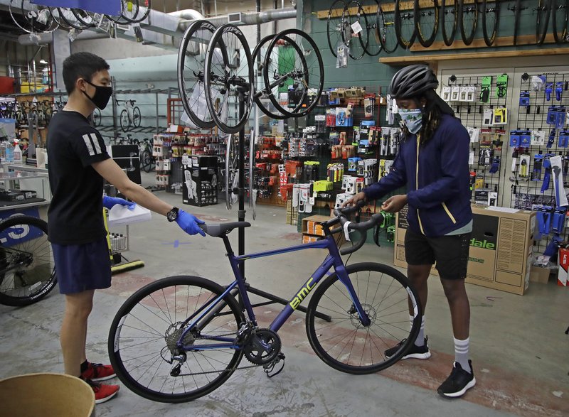 Joel Johnson, right, takes delivery of his new bicycle on May 16 at the Sports Basement store in San Francisco. Johnson hadn't owned a bicycle since he was 15, but soon after the coronavirus pandemic led to a shelter in place order in San Francisco, he bought a bike to avoid crowded public trains and buses. He is among thousands of cooped-up Americans snapping up new bicycles or dusting off decades-old bikes to stay fit, keep their mental sanity or have a safe alternative to public transportation. - AP Photo/Ben Margot