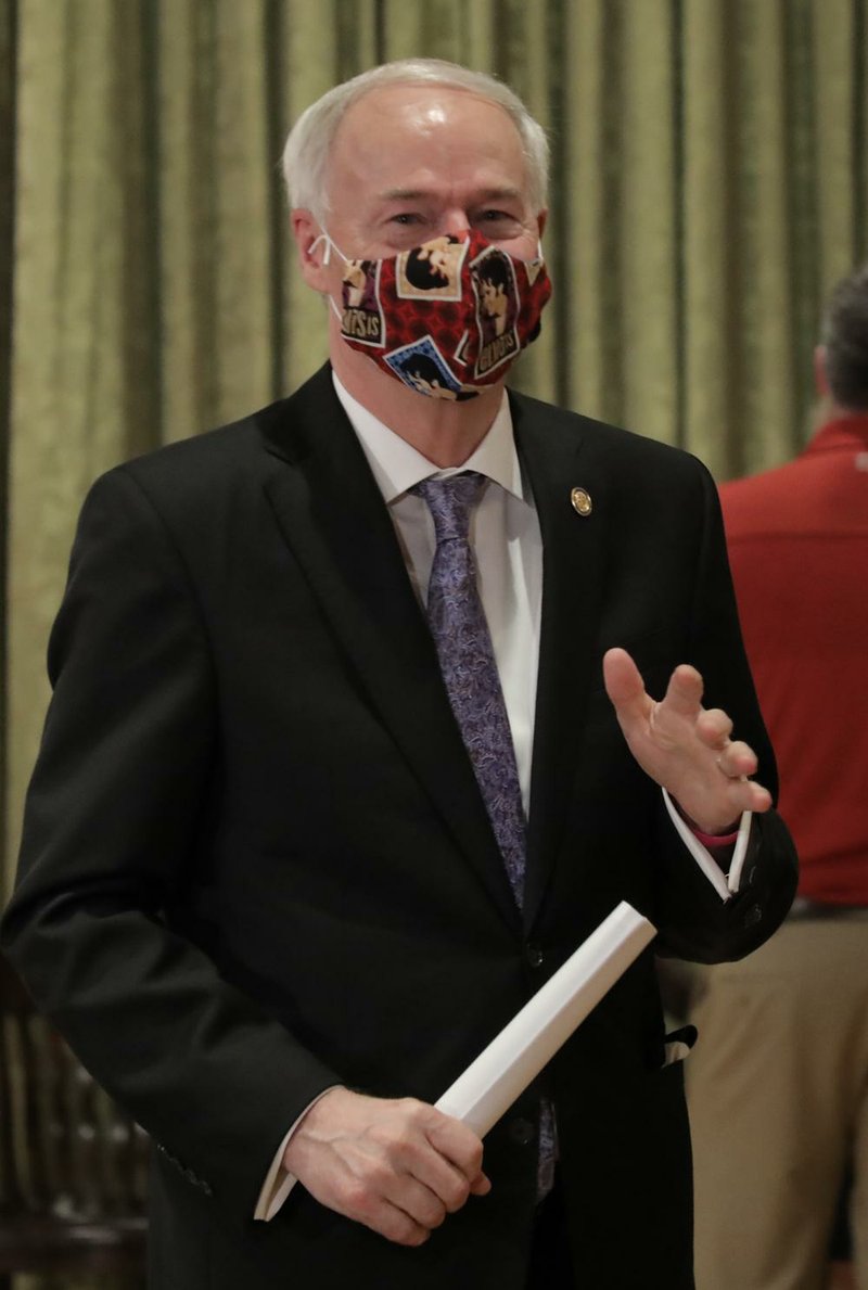 Fully masked, Gov. Asa Hutchinson departs the governor's conference room after a discussion of infection numbers during the daily COVID-19 briefing on Friday May 22, 2020, at the state capitol in Little Rock. (Arkansas Democrat-Gazette)