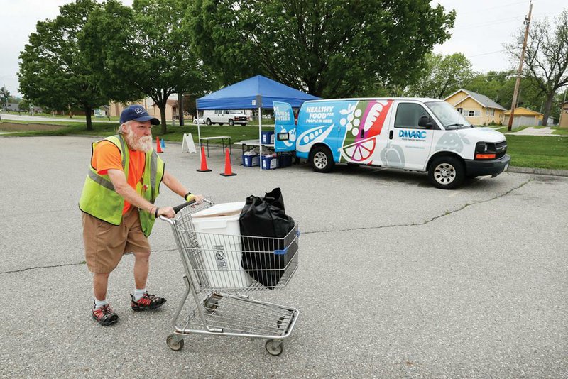 Lewis Claussen picks up food last week at a Des Moines Area Religious Council food pantry site in Iowa. (AP/Charlie Neibergall) 
