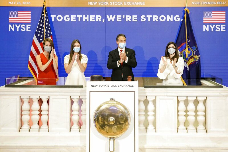 In this image provided by the New York Stock Exchange, New York State Gov. Andrew Cuomo, center, applauds as he rings the opening bell of the New York Stock Exchange with with New York Stock Exchange President Stacey Cunningham, right, Tuesday, May 26, 2020 in New York.