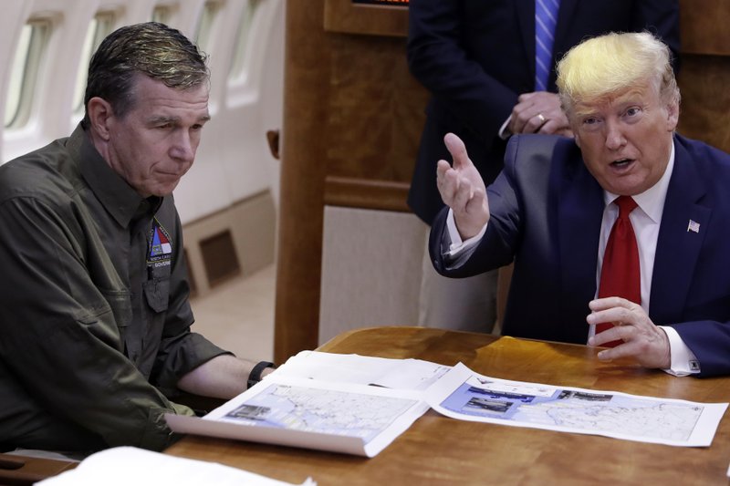 FILE - In this Sept. 9, 2019, file photo, President Donald Trump participates in a briefing about Hurricane Dorian with North Carolina Gov. Roy Cooper, left, aboard Air Force One at Marine Corps Air Station Cherry Point in Havelock, N.C. President Donald Trump demanded Monday, May 25, 2020, that North Carolina's Democratic governor sign off "immediately" on allowing the Republican National Convention to move forward in August with full attendance despite the ongoing COVID-19 pandemic. Trump's tweets Monday about the RNC, planned for Charlotte, come just two days after the North Carolina recorded its largest daily increase in positive cases yet.(AP Photo/Evan Vucci)