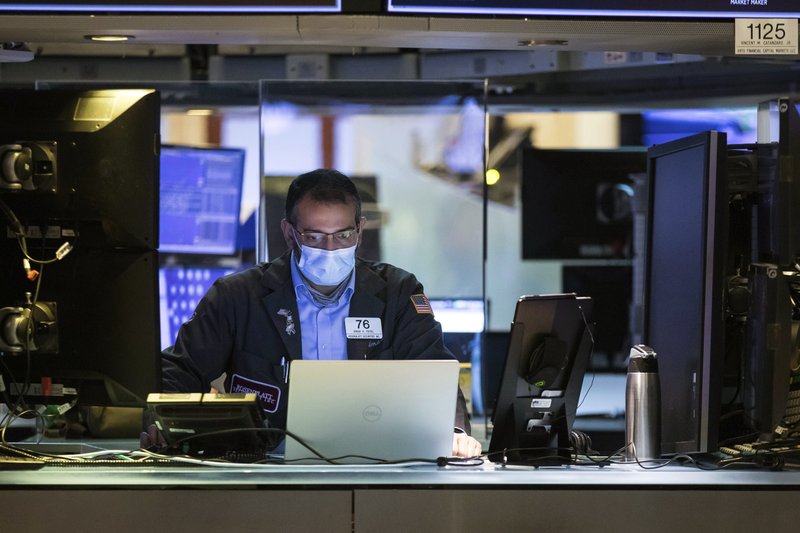 In this photo provided by the New York Stock Exchange, trader Aman Patel wears a protective face mask as he works on the partially reopened trading floor, Tuesday, May 26, 2020. Stocks surged on Wall Street in afternoon trading Tuesday, driving the S&amp;P 500 to its highest level in nearly three months, as hopes for economic recovery overshadow worries about the coronavirus pandemic. (Colin Zimmer/New York Stock Exchange via AP)