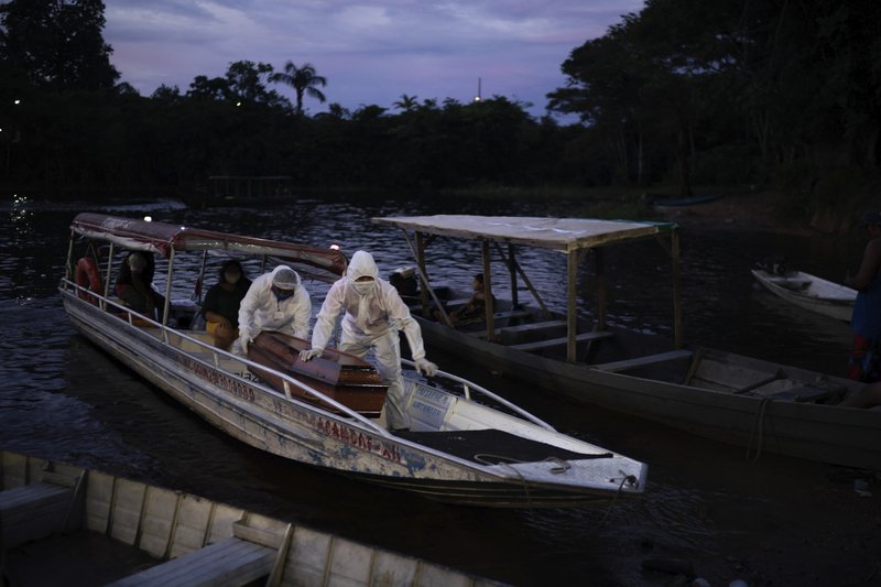 SOS Funeral workers transport by boat a coffin carrying the body of an 86-year-old woman who lived by the Negro River and is a suspected to have died of COVID-19, near Manaus, Brazil, Thursday, May 14, 2020. The virus has spread upriver from Manaus, creeping into remote riverside towns and indigenous territories to infect indigenous tribes. (AP Photo/Felipe Dana)