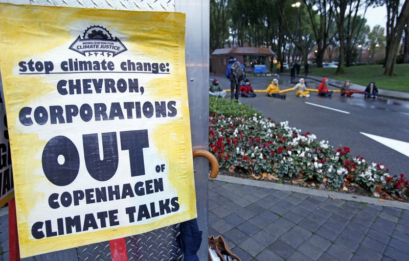 FILE - In this Dec. 7, 2009, file photo, demonstrators block the main entrance of Chevron Corp. in San Ramon, Calif. A federal appeals court ruled Tuesday, May 26, 2020 against major oil companies in lawsuits brought by California cities and counties seeking damages for the impact of climate change. A panel of the 9th U.S. Circuit Court of Appeals said state courts are the proper forum for the lawsuits alleging that Big Oil promoted petroleum as environmentally responsible when producers knew it was causing damage. (AP Photo/Paul Sakuma, File)