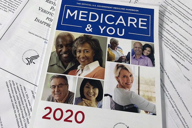 The Official U.S. Government Medicare Handbook for 2020 is shown over pages of a report from the Office of the Inspector General at the Department of Health and Human Services in this Feb. 13, 2020, file photo. (AP Photos/Wayne Partlow, File)