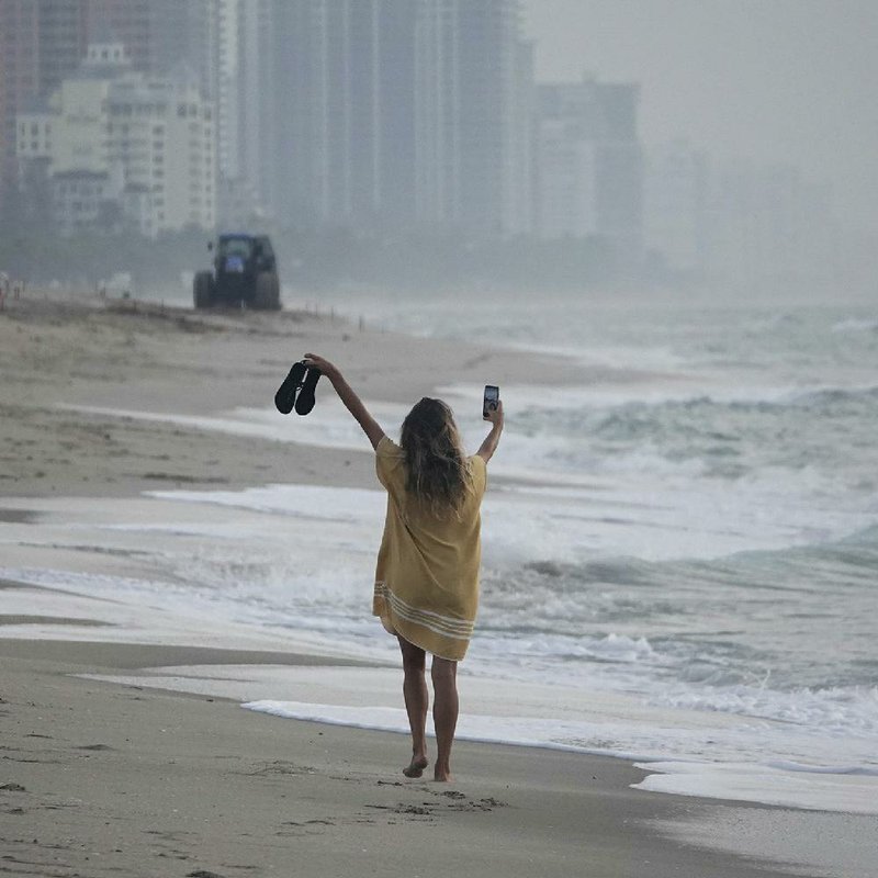 A woman walks on the beach Tuesday in Fort Lauderdale, Fla., as Broward County allowed public access to beaches, hotels and gyms, with certain restrictions. More photos at arkansasonline.com/527covid/. (AP/South Florida Sun-Sentinel/Joe Cavaretta) 
