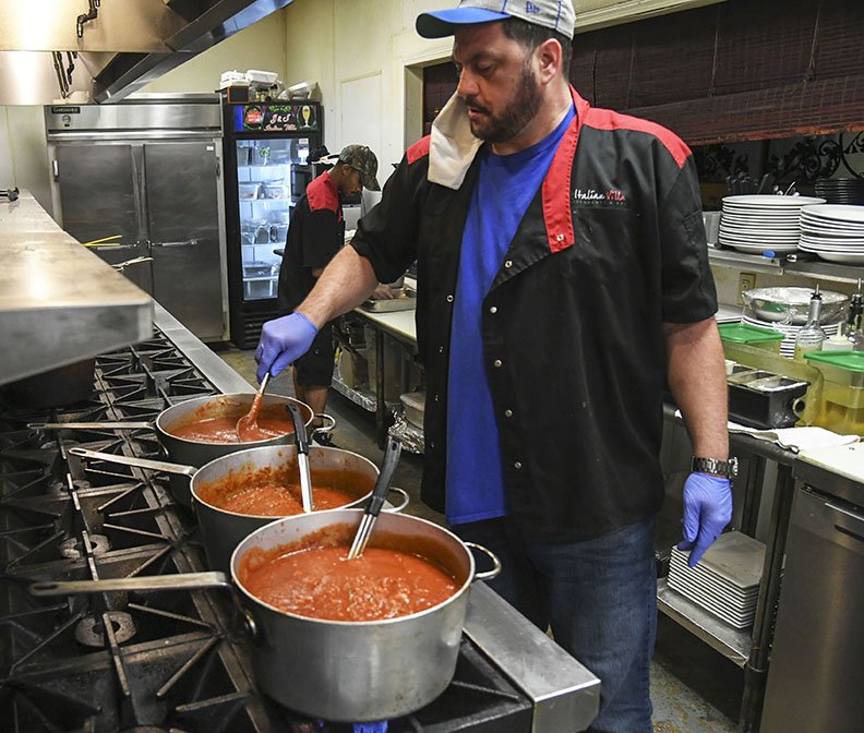 Joe Nash, cook at J&S; Italian Villa, stirs the restaurant's "holy trinity" of red sauces prior to opening Wednesday. The restaurant was recently acquired by the owner of Bone's Chophouse. -Photo by Grace Brown of The Sentinel-Record