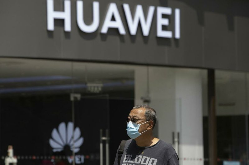 A man passes a Huawei retail store earlier this month in Beijing. A judge in Canada ruled Wednesday the U.S. extradition case against a senior Huawei executive can continue.
(AP/Ng Han Guan)