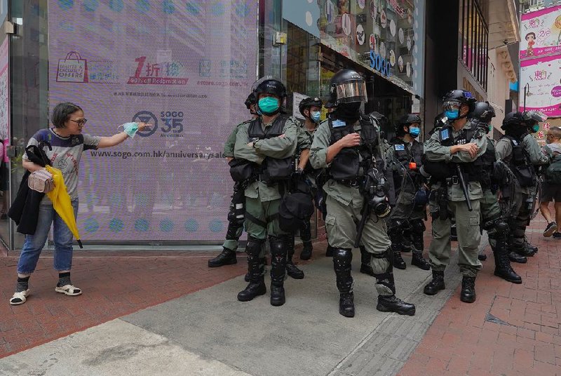 A woman confronts Hong Kong riot police Wednesday as she tries to cross a street. Police were on watch for protesters as lawmakers debated a bill to protect China’s national anthem.
(AP/Vincent Yu)