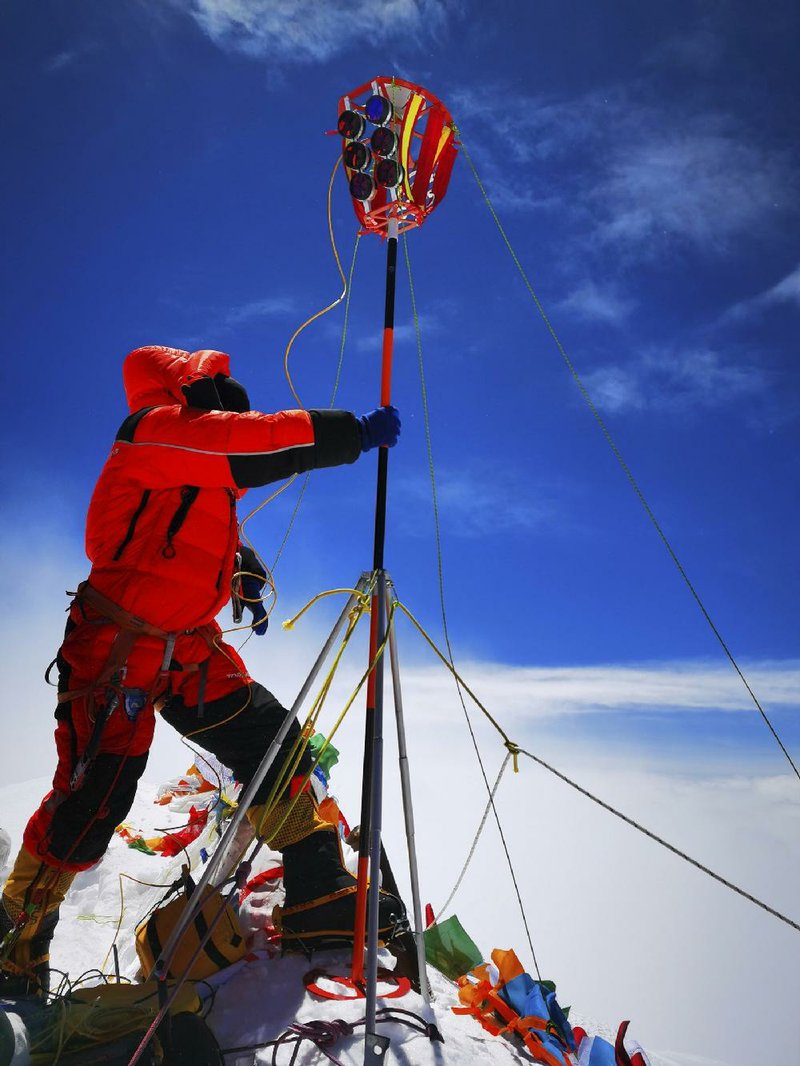 A member of a Chinese team sets up surveying equipment Wednesday on the summit of Mount Everest.
(AP/Xinhua/Tashi Tsering)