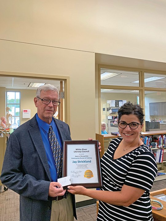 Gia Taylor, vice president of the White River Literacy Council, presents Jay Strickland of the University of Arkansas Community College at Batesville with the council’s 2020 Community Person in Literacy award.