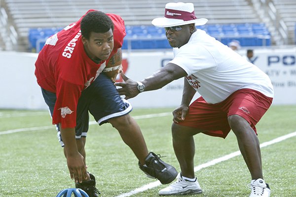 Former Arkansas running back Oscar Malon (right) works with Malcomb Watson of Brinkley while coaching at the Brandon Burlsworth Football Camp on Saturday, June 5, 2004, at War Memorial Stadium in Little Rock. The Burlsworth camps have been hosted each year since 2000 in Harrison and Little Rock, but will be moved to a virtual setting this year because of the covid-19 outbreak.
