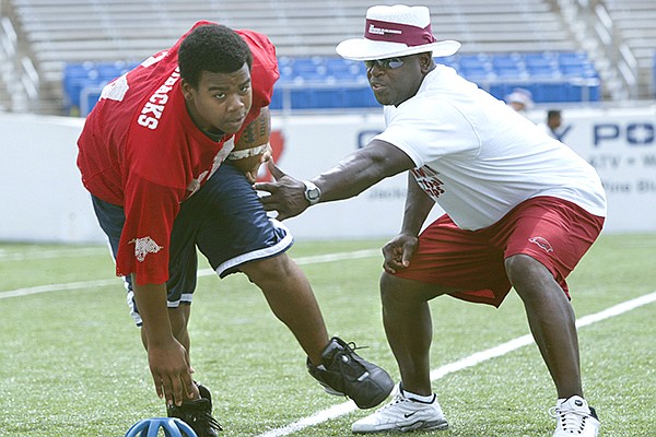 Former Arkansas running back Oscar Malon (right) works with Malcomb Watson of Brinkley while coaching at the Brandon Burlsworth Football Camp on Saturday, June 5, 2004, at War Memorial Stadium in Little Rock. The Burlsworth camps have been hosted each year since 2000 in Harrison and Little Rock, but will be moved to a virtual setting this year because of the covid-19 outbreak. 