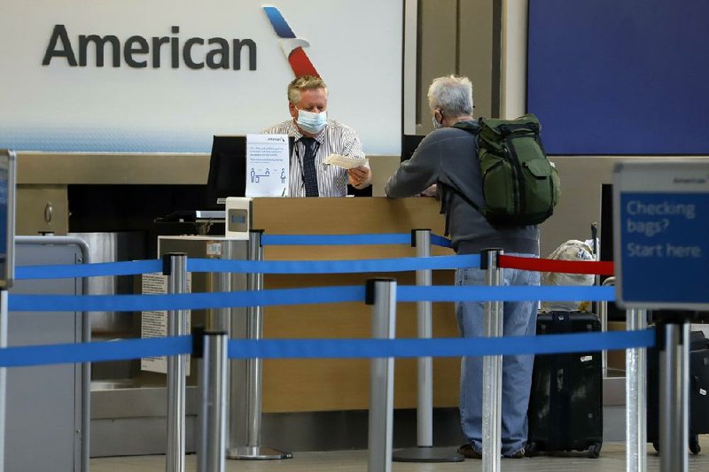 A traveler checks in earlier this month at the American Airline ticket counter at Greater Pittsburgh International Airport. American Airlines plans to cut its by 30%. More photos at arkansasonline.com/529jobs/
(AP/Gene J. Puskar)