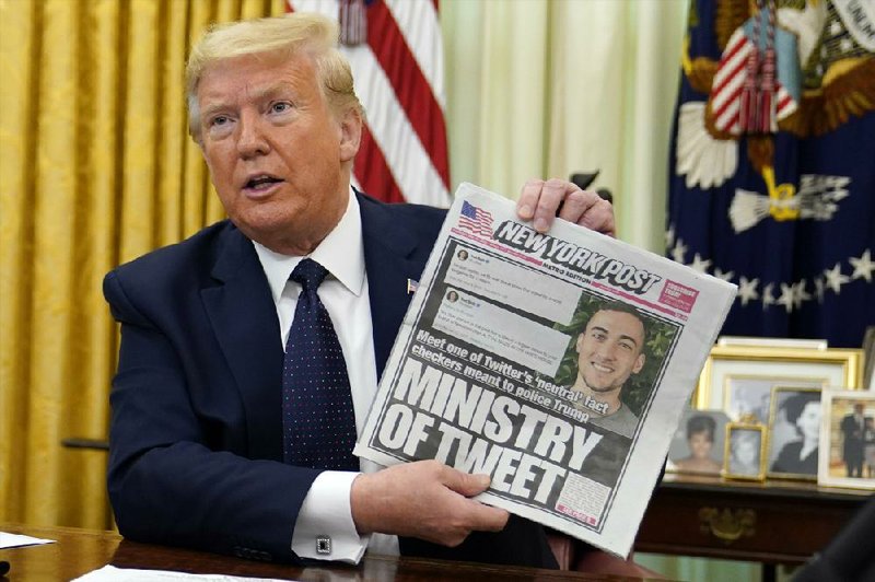 In the Oval Office on Thursday, President Donald Trump holds up a copy of the New York Post before signing an executive order aimed at curbing protections for social media.
(AP/Evan Vucci)