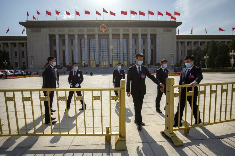 Security personnel pull gates Thursday in front of the Great Hall of the People after the closing session of China’s National People’s Congress in Beijing. More photos at arkansasonline.com/529hongkong/
(AP/Mark Schiefelbein)