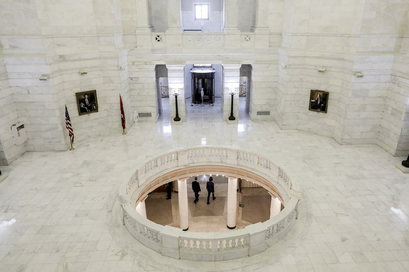 Two men leave the state Capitol after a recent news briefing. The building is to reopen Monday, but for now signs warn visitors away.
(Arkansas Democrat-Gazette/ John Sykes Jr.)