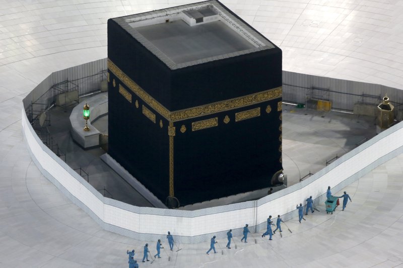 In this March 7, 2020, file photo, workers disinfect the ground around the Kaaba, the cubic building at the Grand Mosque, in the Muslim holy city of Mecca, Saudi Arabia, which emptied Islam's holiest site for what they say sterilization over fears of the new coronavirus. The Islamic State group in an audio message released late Thursday, May 28, 2020, blasted Iraq's new prime minister, calling him an "American agent" and criticizing the closure of Islam's holiest shrine in the Saudi holy city of Mecca to limit the spread of coronavirus. (AP Photo/Amr Nabil, File)