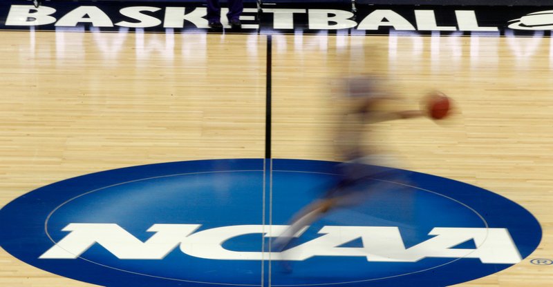 A player runs across the NCAA logo during practice in Pittsburgh before a March 14, 2012, NCAA basketball tournament game. The NCAA released a plan to help schools bring back athletes to campus during a pandemic on Friday. - Photo by Keith Srakocic of The Associated Press