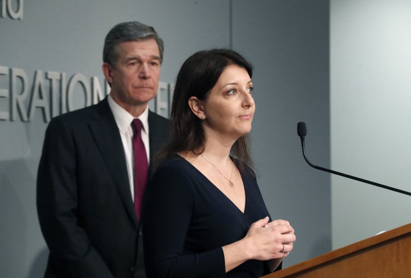 Dr. Mandy Cohen, secretary of the state Department of Health and Human Services, speaks during North Carolina Gov. Roy Cooper's, left, briefing on the coronavirus pandemic at the Emergency Operations Center in Raleigh, N.C., Thursday, May 28, 2020. (Ethan Hyman/The News &amp; Observer via AP)