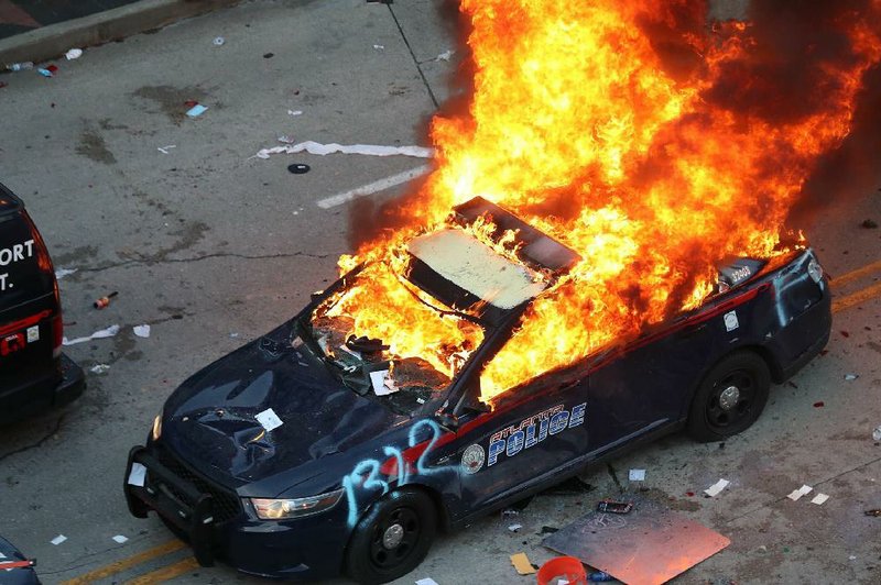 A police car burns Friday in Atlanta after protesters marched to the Georgia Capitol and back to an area around CNN headquarters. The building was damaged and police were pelted with bottles.
(AP/Atlanta Journal-Constitution/Alyssa Pointer)