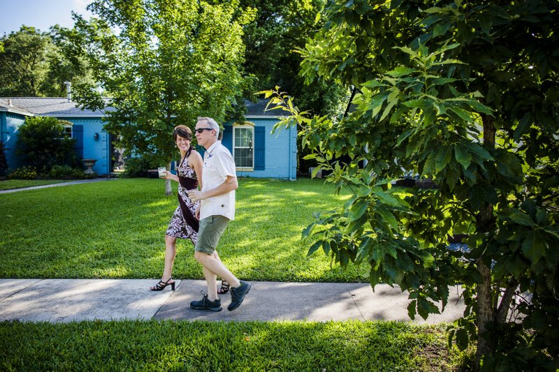 Pam and Chris LeBlanc enjoy a cocktail while on a walk in their neighborhood in Austin, Texas, earlier this month. With most bars still takeout only, indoor gatherings discouraged and the weather warmer, Americans are sipping and strolling. (The New York Times/Drew Anthony Smith) 