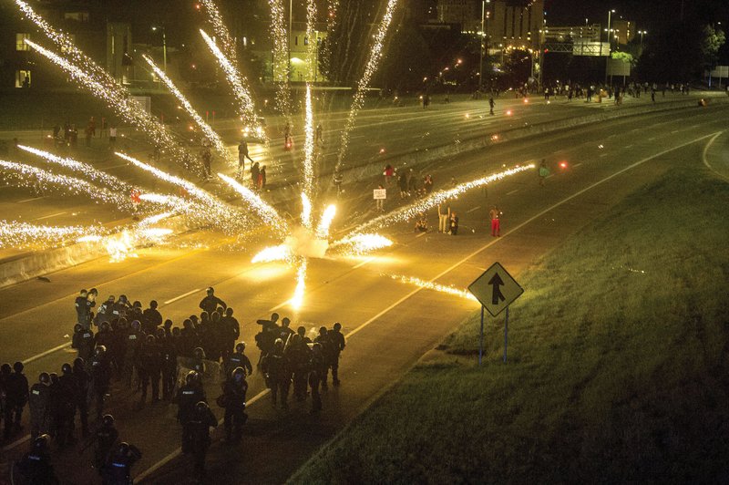 Protesters throw fireworks at police officers Saturday evening as they block Interstate 630 during a protest in downtown Little Rock over the killing of George Floyd in Minneapolis. More photos at arkansasonline.com/531lr/.
(Arkansas Democrat-Gazette/Stephen Swofford)