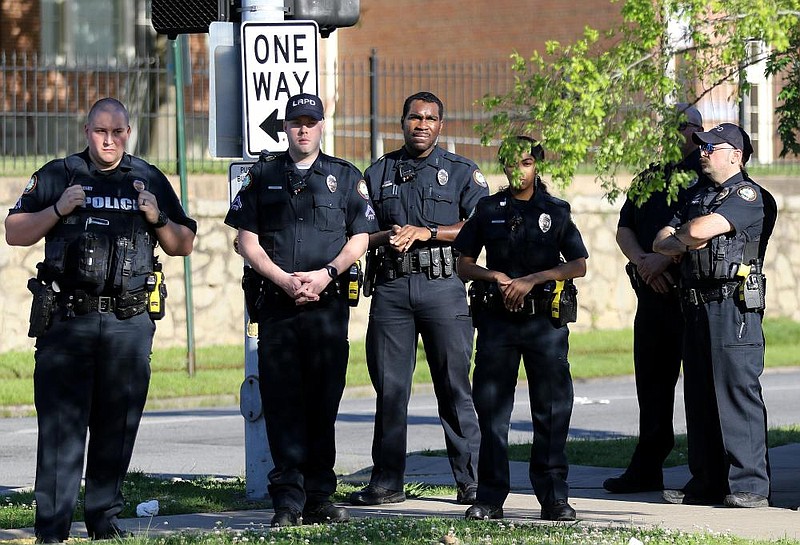 Little Rock Police officers watch protesters march outside the Little Rock Police Department's 12th Street Station on Sunday, May 31, 2020.
(Arkansas Democrat-Gazette/Thomas Metthe)