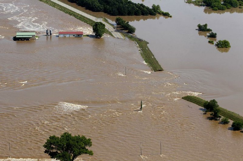 Water pours through the breached Dardanelle levee in Yell County south of Dardanelle a year ago. Repair work is set to begin on the levee in the next two weeks. Other levees are also awaiting needed repairs.
(Arkansas Democrat-Gazette/Thomas Metthe)
