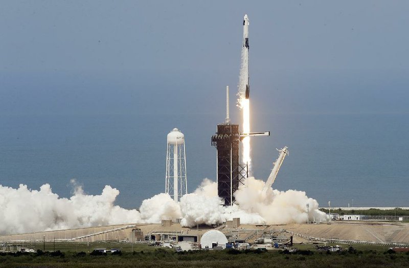 The SpaceX Falcon 9 roars to life Saturday on Pad 39-A at the Kennedy Space Center, carrying NASA astronauts Doug Hurley and Bob Behnken aboard the Dragon crew capsule toward a docking today with the International Space Station. More photos at arkansasonline.com/531spacex/.
(AP/Chris O’Meara)