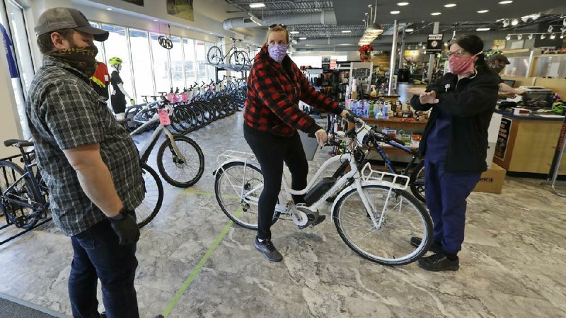 In this photo taken earlier in May, store manager Josh Hayden, left to right, talks with Kay Amey and Jackie Gee about a new bicycle at Eddy’s Bike Shop in Willoughby Hills, Ohio.
(AP/Tony Dejak)