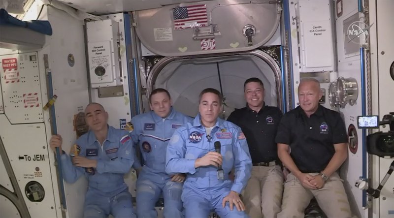 This photo provided by NASA shows Bob Behnken and Doug Hurley, far right, joining the the crew at the International Space Station, after the SpaceX Dragon capsule pulled up to the station and docked Sunday. The Dragon capsule arrived Sunday morning, hours after a historic liftoff from Florida. It's the first time that a privately built and owned spacecraft has delivered a crew to the orbiting lab. - NASA via AP