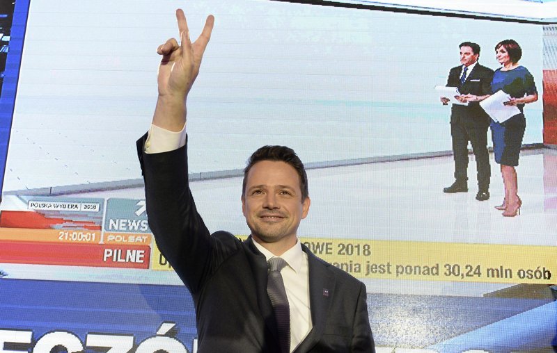 FILE - In this Sunday, Oct. 21, 2018 file photo Warsaw city mayor candidate from the main opposition party Civic Platform, Rafal Trzaskowski reacts as first exit polls indicating him as the winner are announced in Warsaw, Poland. Trzaskowski, a pro-European Union liberal, has recently joined the race for the nation's president and has emerged as the main challenger to incumbent President Andrzej Duda who had previously seemed certain to win. The date of the vote is yet to be announced. (AP Photo/Alik Keplicz, File)