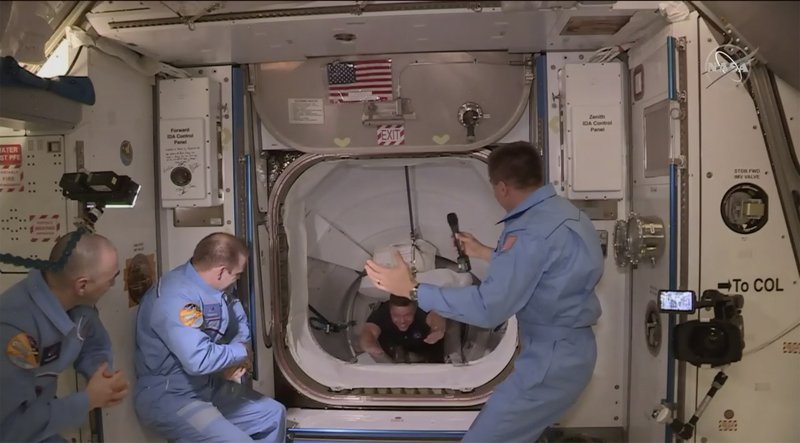 This photo provided by NASA shows the crew of SpaceX entering the International Space Station, Sunday, May 31, 2020. The Dragon capsule arrived Sunday morning, hours after a historic liftoff from Florida. It's the first time that a privately built and owned spacecraft has delivered a crew to the orbiting lab. (NASA via AP)