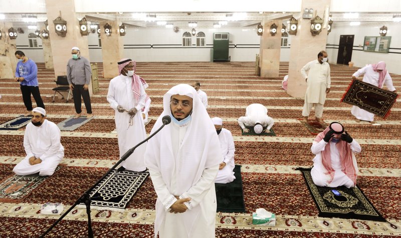 Saudi cleric Hammoud Al-Labban recites the call to prayers Sunday as worshippers wearing face masks and observing social distancing guidelines to protect against the new coronavirus, attend dawn prayers at al-Mirabi Mosque in Jiddah, Saudi Arabia. (AP/Amr Nabil) 
