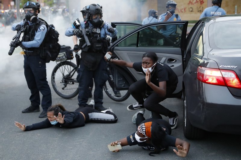 The Associated Press PROTESTERS: Motorists are ordered to the ground from their vehicle by police during a protest on South Washington Street, Sunday, in Minneapolis. Protests continued following the death of George Floyd, who died after being restrained by Minneapolis police officers on Memorial Day.