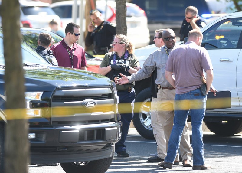 Law enforcement personnel work the scene Monday at a parking lot near the Community Clinic at 3162 W. Martin Luther King Jr. Blvd. in Fayetteville where U.S. Marshals shot a man Monday morning in his car in the parking lot according to Sgt. Anthony Murphy, Fayetteville police spokesman. Go to nwaonline.com/200602Daily/ and nwadg.com/photos for a photo gallery. (NWA Democrat-Gazette/David Gottschalk)