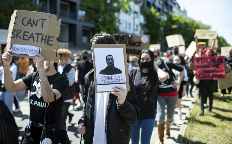 People protest in Berlin, Germany, Sunday, May 31, 2020 after the violent death of the African-American George Floyd by a white policeman in the USA against racism and police violence, among other things with a sign &quot;I can't breathe&quot;. (Bernd von Jutrczenka/dpa via AP)