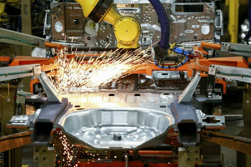 FILE - In this June 24, 2019, file photo machines work on a Ford vehicle assembly line at Ford's Chicago Assembly Plant in Chicago. Ford, General Motors and FCA factories have been idled for over a month due to fears of spreading the coronavirus.