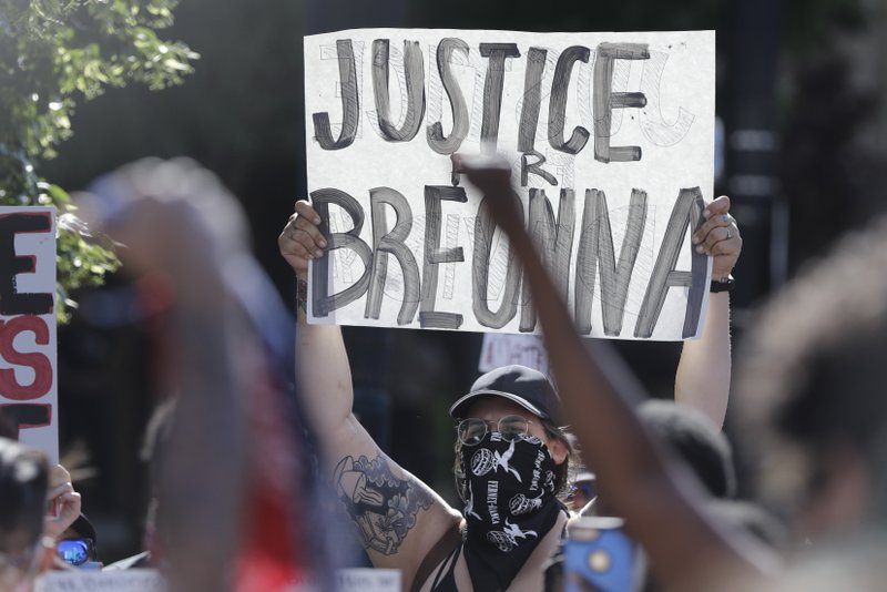 A protester holds a sign during a protest over the deaths of George Floyd and Breonna Taylor, Monday, June 1, 2020, in Louisville, Ky. Breonna Taylor, a black woman, was fatally shot by police in her home in March. (AP Photo/Darron Cummings)