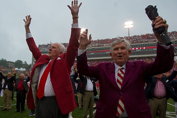 Johnny Majors (right) and Frank Broyles participate in a Hog Call prior to an Arkansas game against Alabama on Oct. 11, 2014, in Fayetteville. The men were on the field for a ceremony celebrating the 50th anniversary of the Razorbacks' 1964 national championship team. Majors was an assistant coach for Broyles for four seasons from 1964-67.