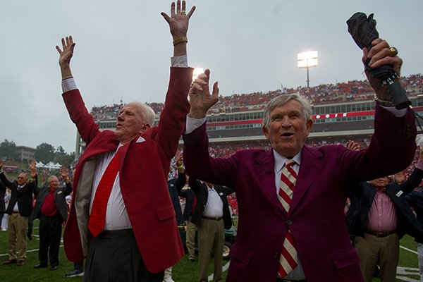Johnny Majors (right) and Frank Broyles participate in a Hog Call prior to an Arkansas game against Alabama on Oct. 11, 2014, in Fayetteville. The men were on the field for a ceremony celebrating the 50th anniversary of the Razorbacks' 1964 national championship team. Majors was an assistant coach for Broyles for four seasons from 1964-67. 