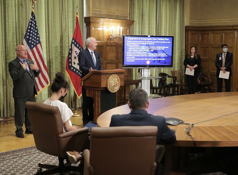 Governor Asa Hutchinson, at podium, talks to local media about the effects of the COVID-19 virus on the state at the governor’s conference room Wednesday afternoon in Little Rock. (Arkansas Democrat-Gazette/John Sykes Jr.)